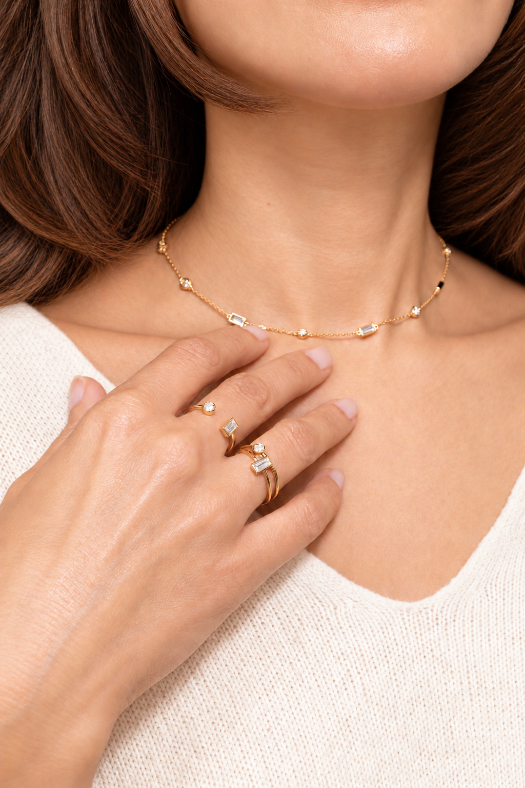Close-up of a woman wearing A. Atelier’s delicate 18K yellow gold Signature Choker and Signature Rings rings, featuring round and baguette diamonds,