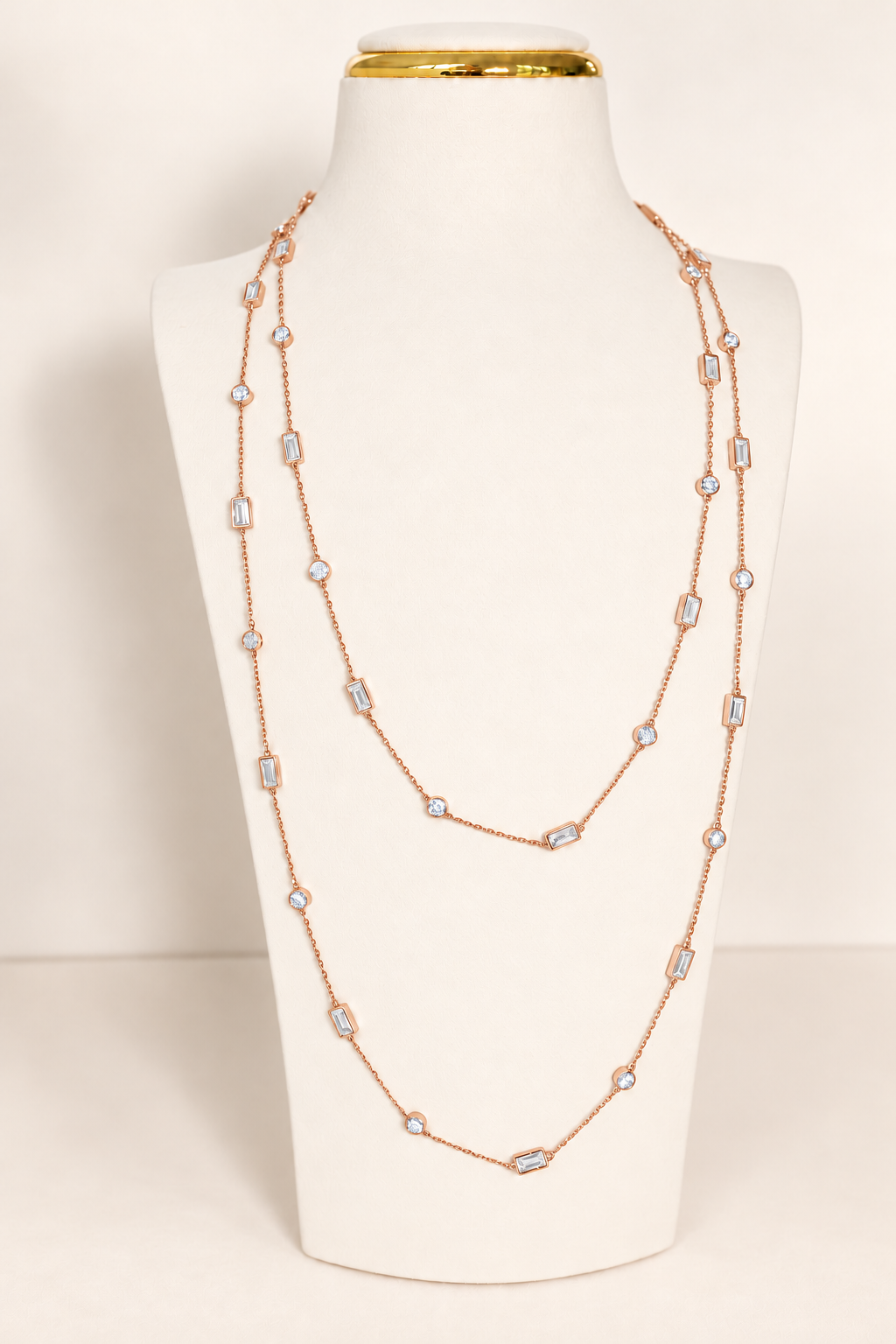 Delicate A. Atelier Signature Long Necklace in 18K rose gold, doubled on a cream necklace stand.