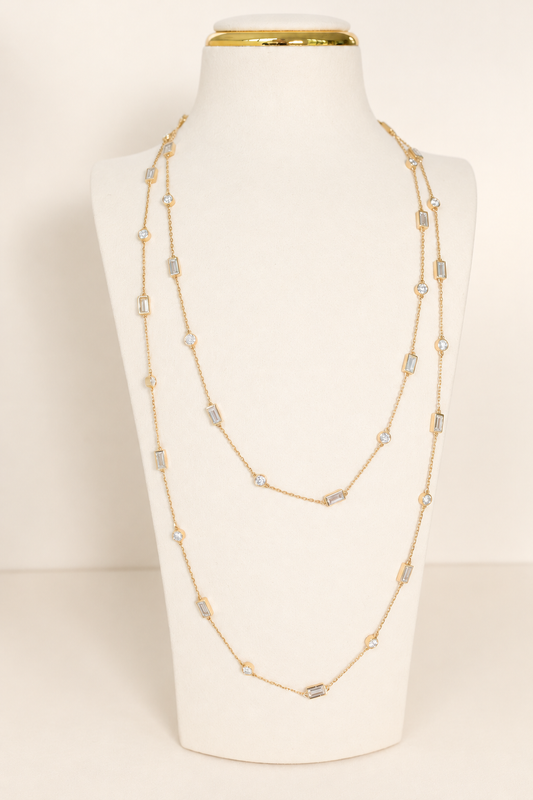 Delicate A. Atelier Signature Long Necklace in 18K yellow gold, doubled on a cream necklace stand.